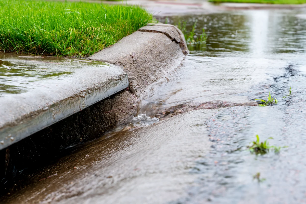 Urban water rethink Stormwater rushing into a street intake drain after heavy rain.