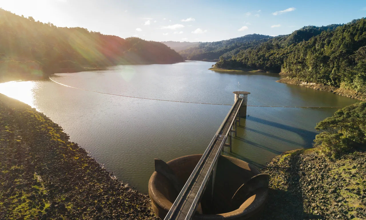 aerial-view-water-treatment Aerial view of a dam intake tower and walkway beside a forested reservoir